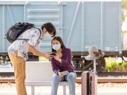 young-male-traveler-backpack-with-mask-mobile-hand-asking-way-help-from-woman-sitting-pointing-stairs-subway-covid-distance_28914-2472