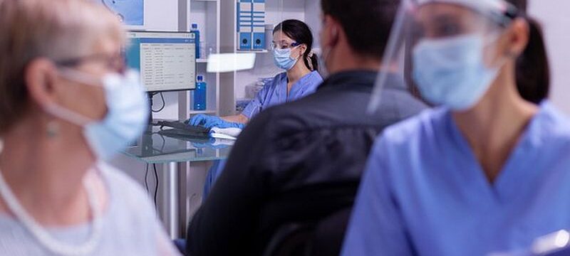 young-nurse-wearing-protection-mask-visor-against-coronavirus-infection-typing-computer-new-patients-appointments_482257-1264