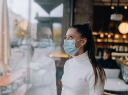 young-woman-face-mask-standing-front-windows-cafe_1153-8035