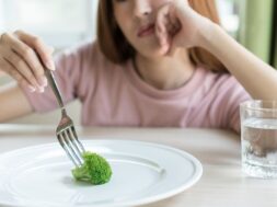 Woman On Dieting. Depressed Teen Looking At Her Empty Plate Dinn