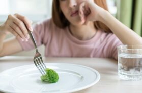 Woman On Dieting. Depressed Teen Looking At Her Empty Plate Dinn