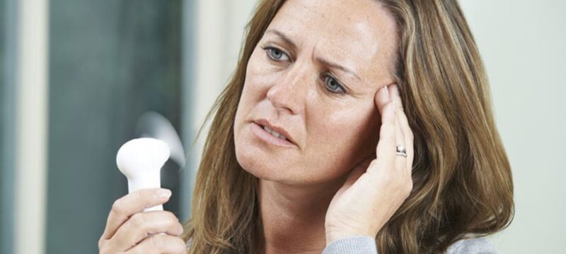 Mature Woman Experiencing Hot Flush From Menopause