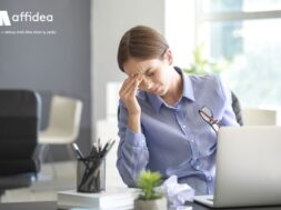 Young woman suffering from headache in office