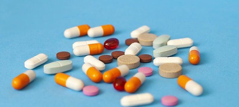 pills are scattered on a blue background