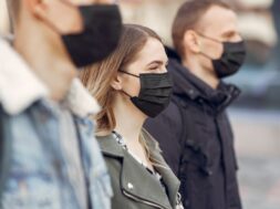 People in a masks stands on the street