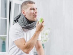 young-man-suffering-from-cold-treats-her-throat-with-spray