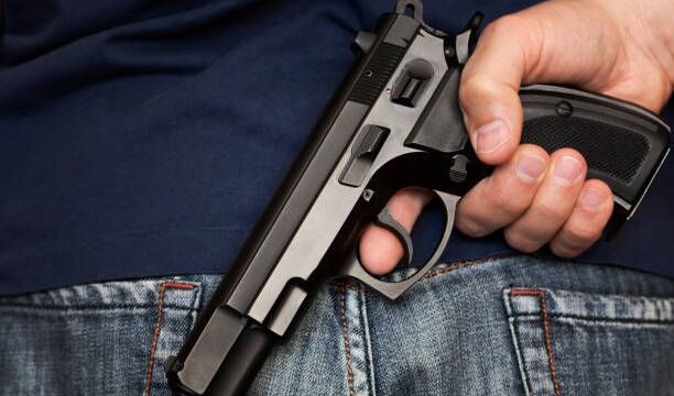 Man holding gun behind his back