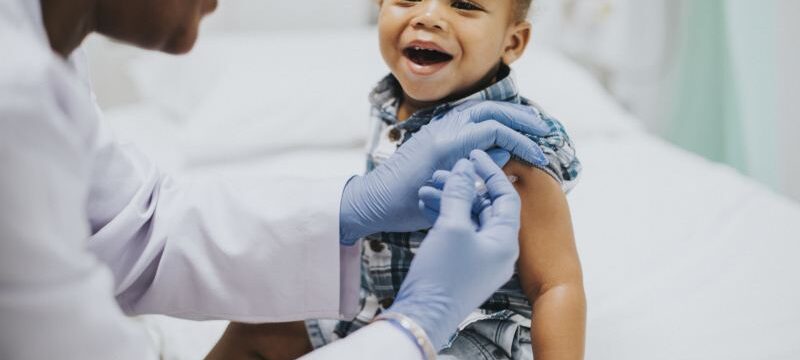Toddler getting a vaccination by a pediatrician