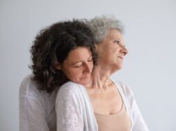 Middle aged daughter hugging senior mother