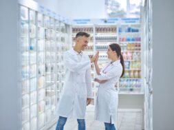 Two people in lab coats feeling good and smiling