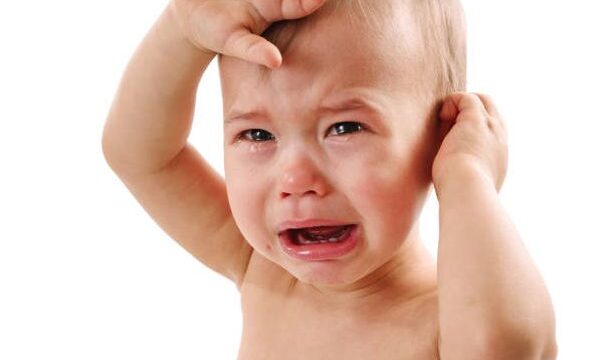 Closeup shot of an adorable upset little  baby boy crying on white background.
