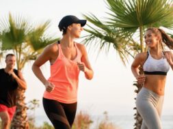 Happy sportswomen communicating while running in nature.
