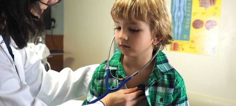 Doctor examining a child with a stethoscope at a hospital