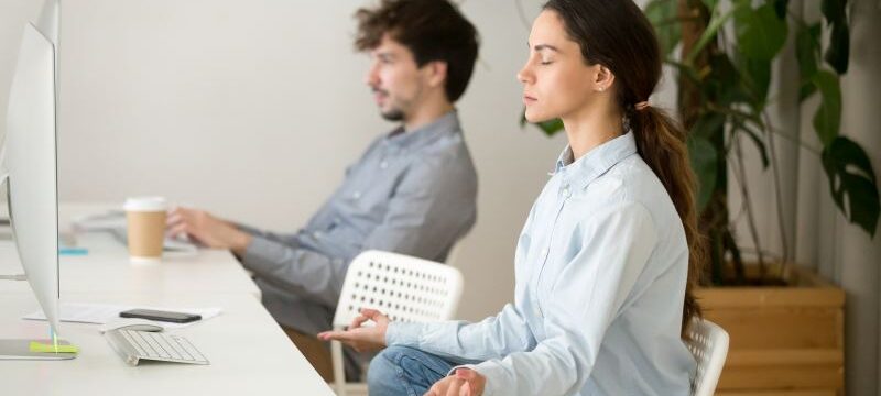 Mindful calm young woman taking break in office for meditation