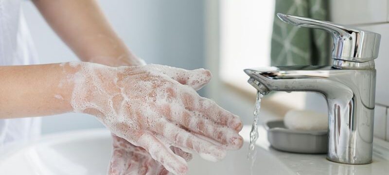 side-view-person-washing-hands-sink