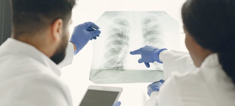 Doctor and coworker standing and looking at x-rays in clinic