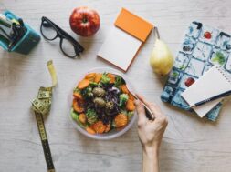 crop-hand-mixing-salad-office
