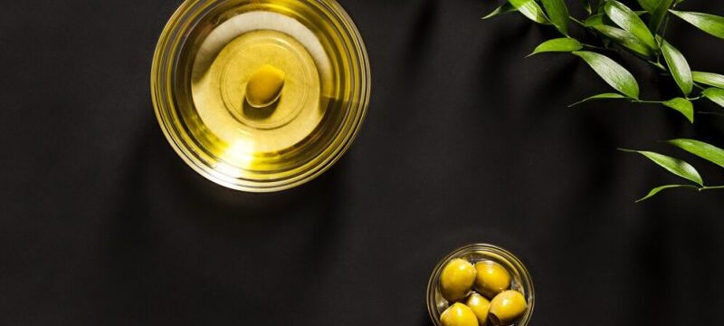 olive-oil-olive-branch-wooden-table_155003-5271