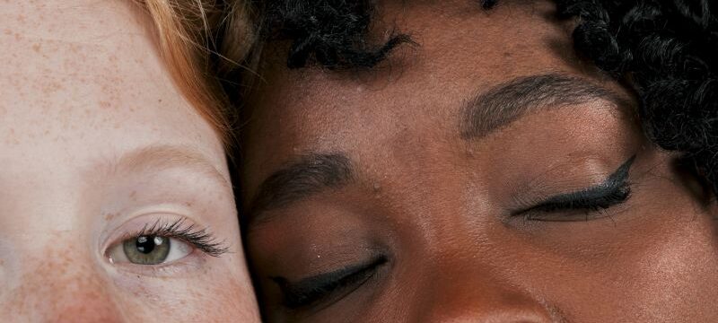 african-woman-face-touching-fair-skinned-female-friend