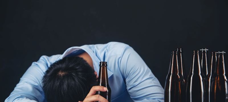 Cropped close up of a man drinking beer at the home