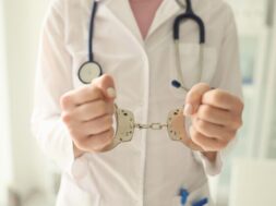 doctor-with-stethoscope-handcuffs-closeup-nurse-with-metal-handcuffs-her-hands-concept_151013-47585