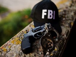 FBI cap with revolver and handcuff.