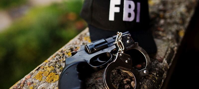 FBI cap with revolver and handcuff.