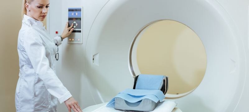 Female radiologist preparing CT scanner for medical examination