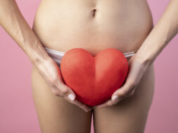 heart-shape-held-by-woman-near-her-reproductive-system