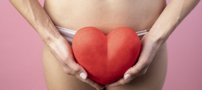 heart-shape-held-by-woman-near-her-reproductive-system