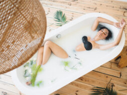 Beautiful lady having a milk bath and looking in empty room .