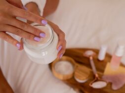 close-up-hands-holding-cream-container_23-2149168519