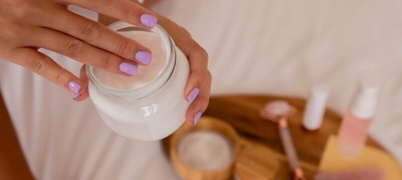 close-up-hands-holding-cream-container_23-2149168519