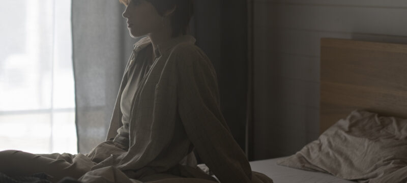 medium-shot-lonely-woman-sitting-bed