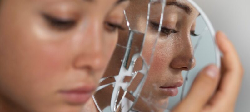 portrait-young-woman-with-low-self-esteem-looking-hand-held-mirror_23-2150038962