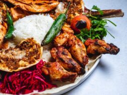 side-view-chicken-kebab-with-grilled-hot-green-pepper-tomato-pickled-cabbage-rice-pita_141793-4837