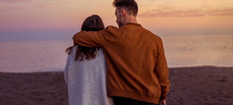 young-couple-hugging-sandy-sea-shore-evening_23-2148020127