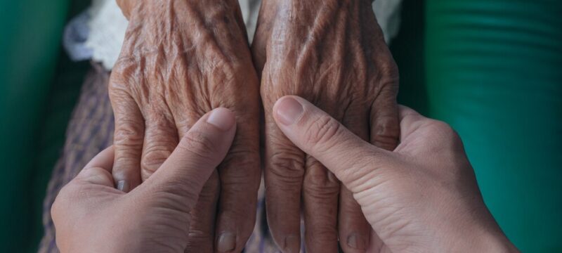 young-woman-holding-elderly-woman-s-hand_1150-12496