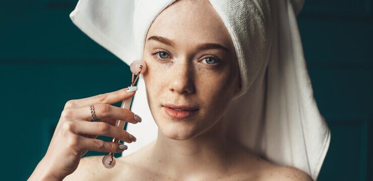 caucasian-ginger-woman-with-freckles-is-massaging-her-face-with-derma-roller-looking-camera-with-bare-shoulders_129180-5924