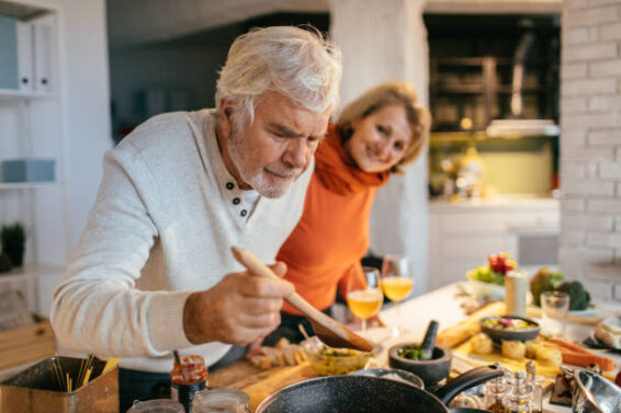 Photo of a senior couple tasting the food they have prepared together