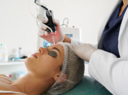 Doctor dermatologist and woman client during laser skin resurfacing treatment
