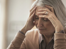 Senior Caucasian woman holding her forehead