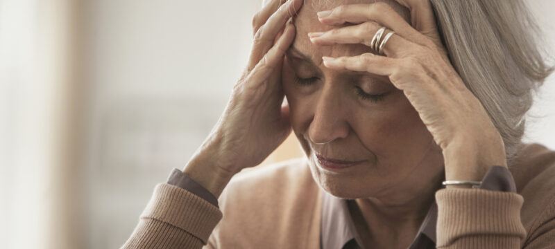 Senior Caucasian woman holding her forehead