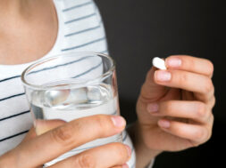 Close,Up,Image,Of,Woman,Putting,White,Round,Pill,In