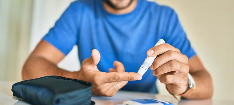 Young,Hispanic,Diabetic,Man,Measuring,Glucose,Level,At,Home