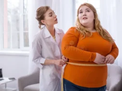 big-weight-serious-professional-doctor-talking-fat-women-measuring-her-concentrated-doctor-talking-plump-woman-116344438