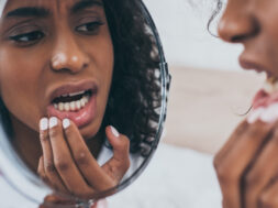 Young,African,American,Woman,Looking,At,Mirror,While,Suffering,From