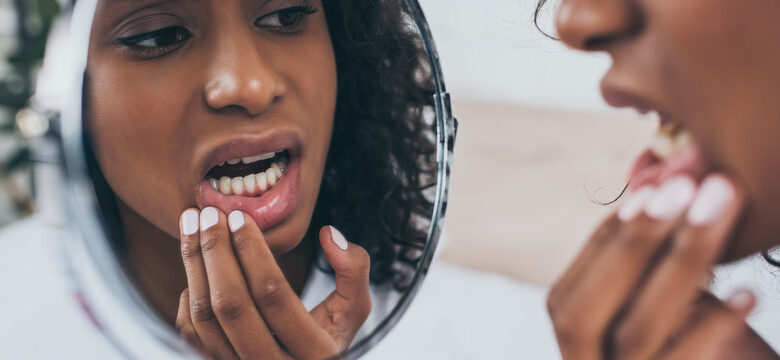 Young,African,American,Woman,Looking,At,Mirror,While,Suffering,From