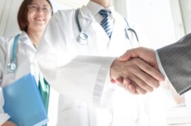 Doctor and business people shaking hands