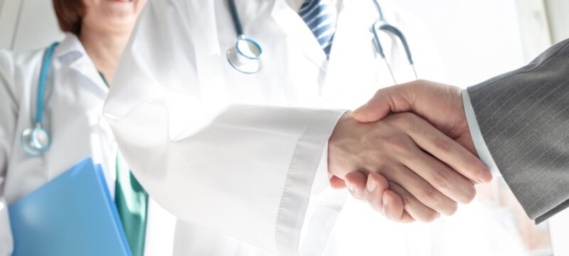 Doctor and business people shaking hands
